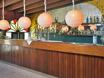 a bar with a wooden counter and white lanterns