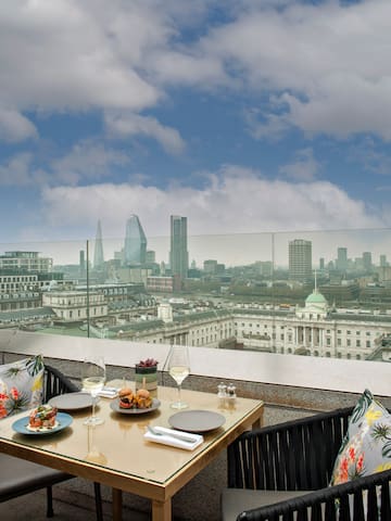 a table with food on it and a city view from a balcony