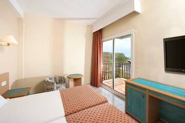 a room with two beds and a table and chairs