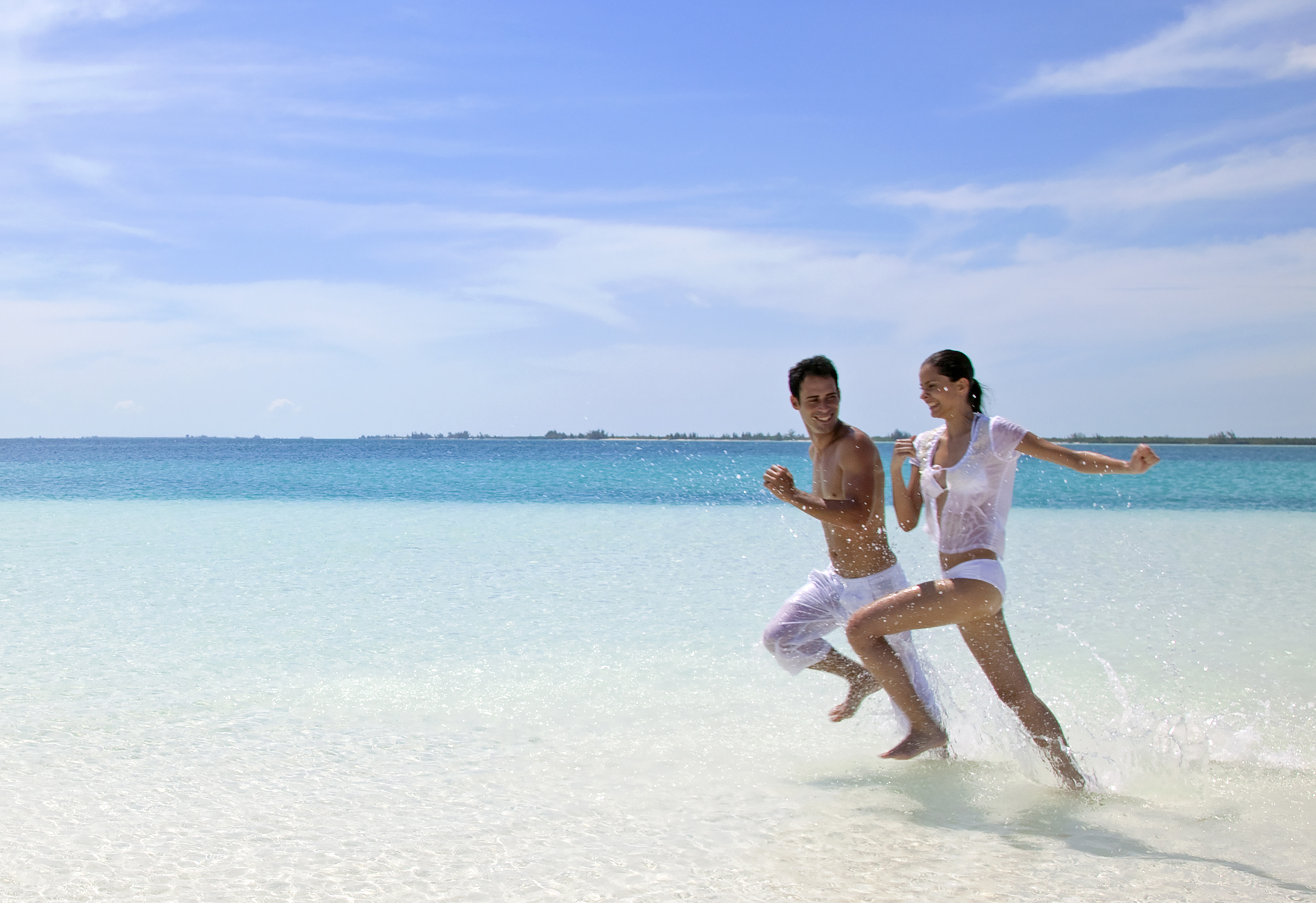 a man and woman running in the water