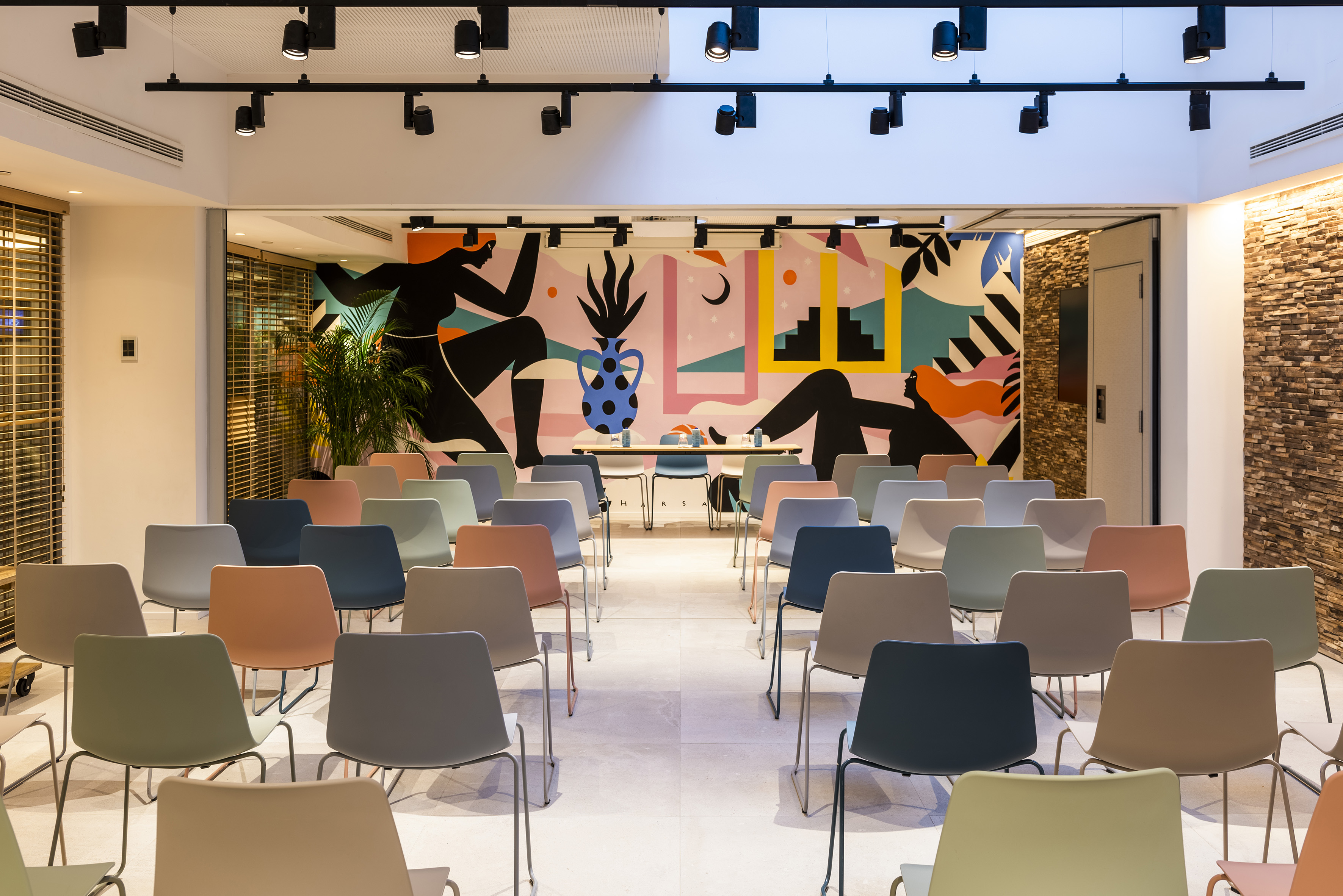 Colorful conference room with vibrant mural and modern seating arrangement.