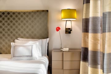 a bed with a lamp and a flower