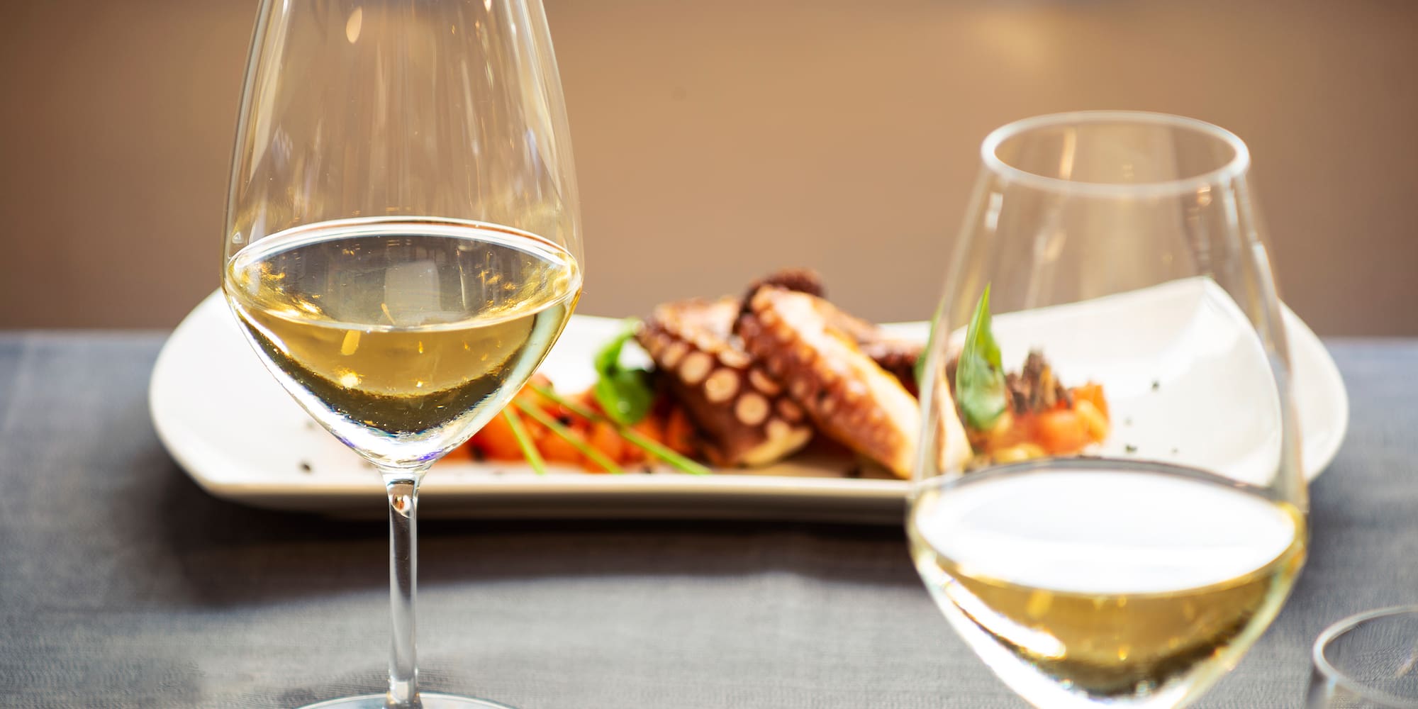 a glass of wine next to a plate of food