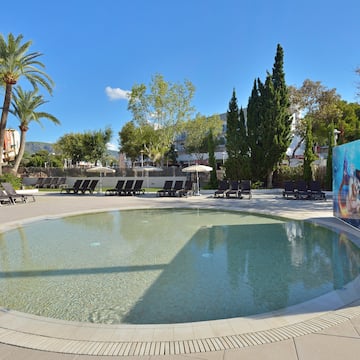 a pool with lounge chairs and trees
