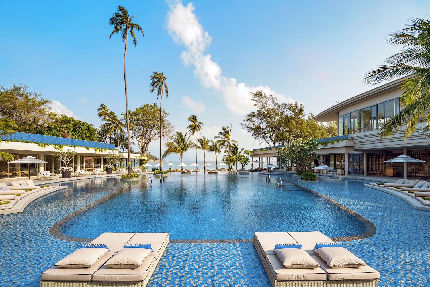 a swimming pool with lounge chairs and palm trees