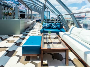 a room with a glass roof and blue couches