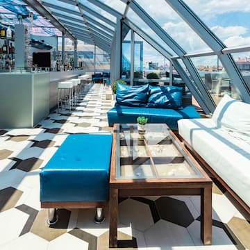 a room with a glass roof and blue couches