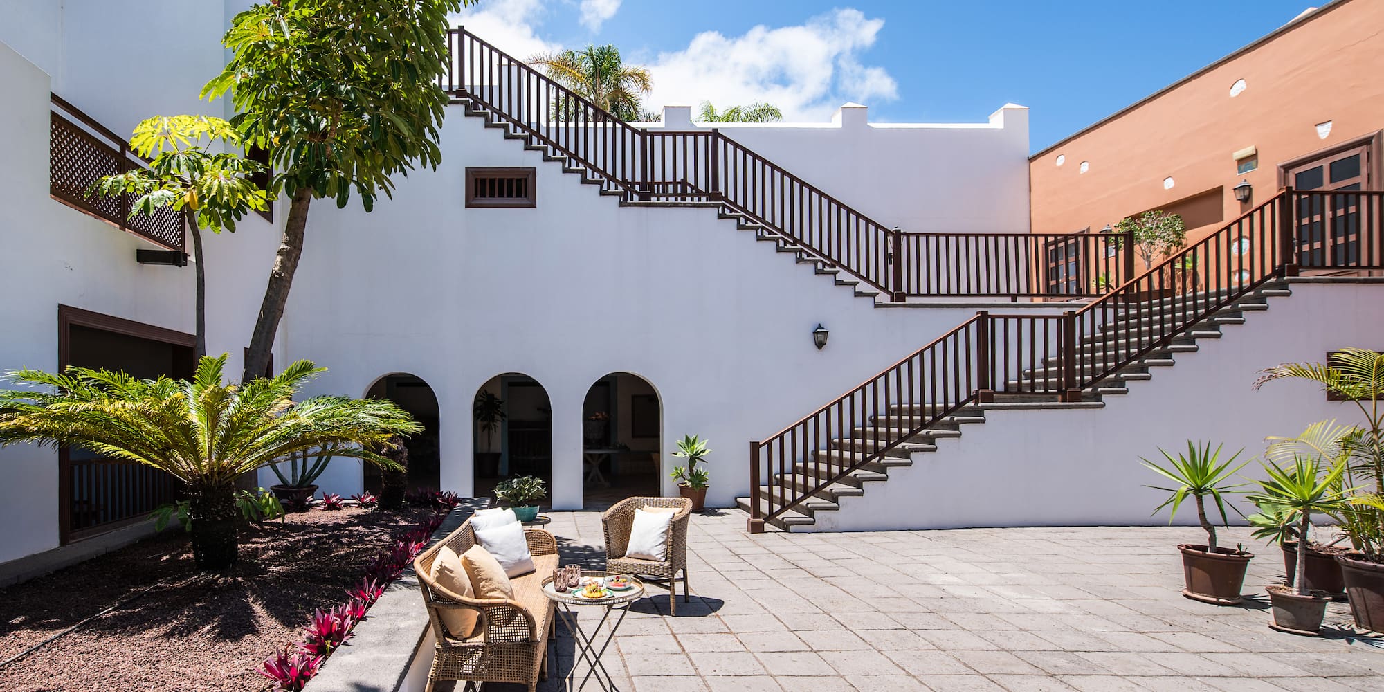 a patio with a table and chairs and a tree