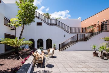 a patio with a table and chairs and a tree