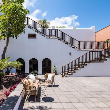 a patio with a table and chairs and a tree