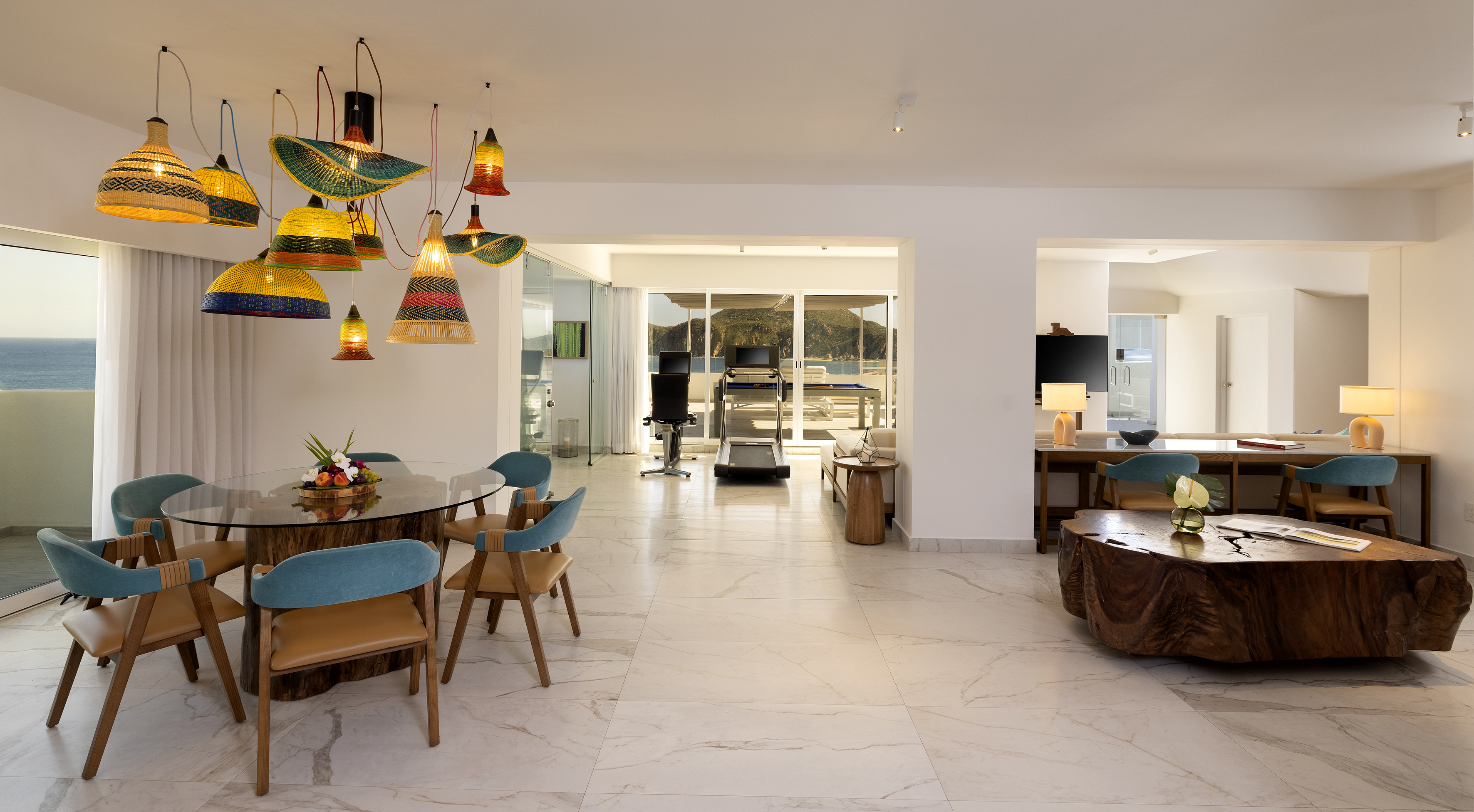 Modern luxury interior with ocean view, dining area, and unique pendant lighting.