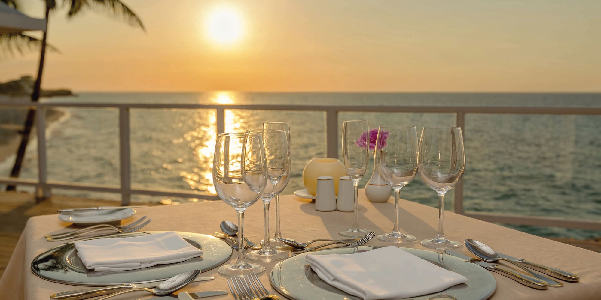 a table set for a dinner with a view of the ocean