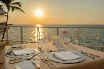 a table set for a dinner with a view of the ocean