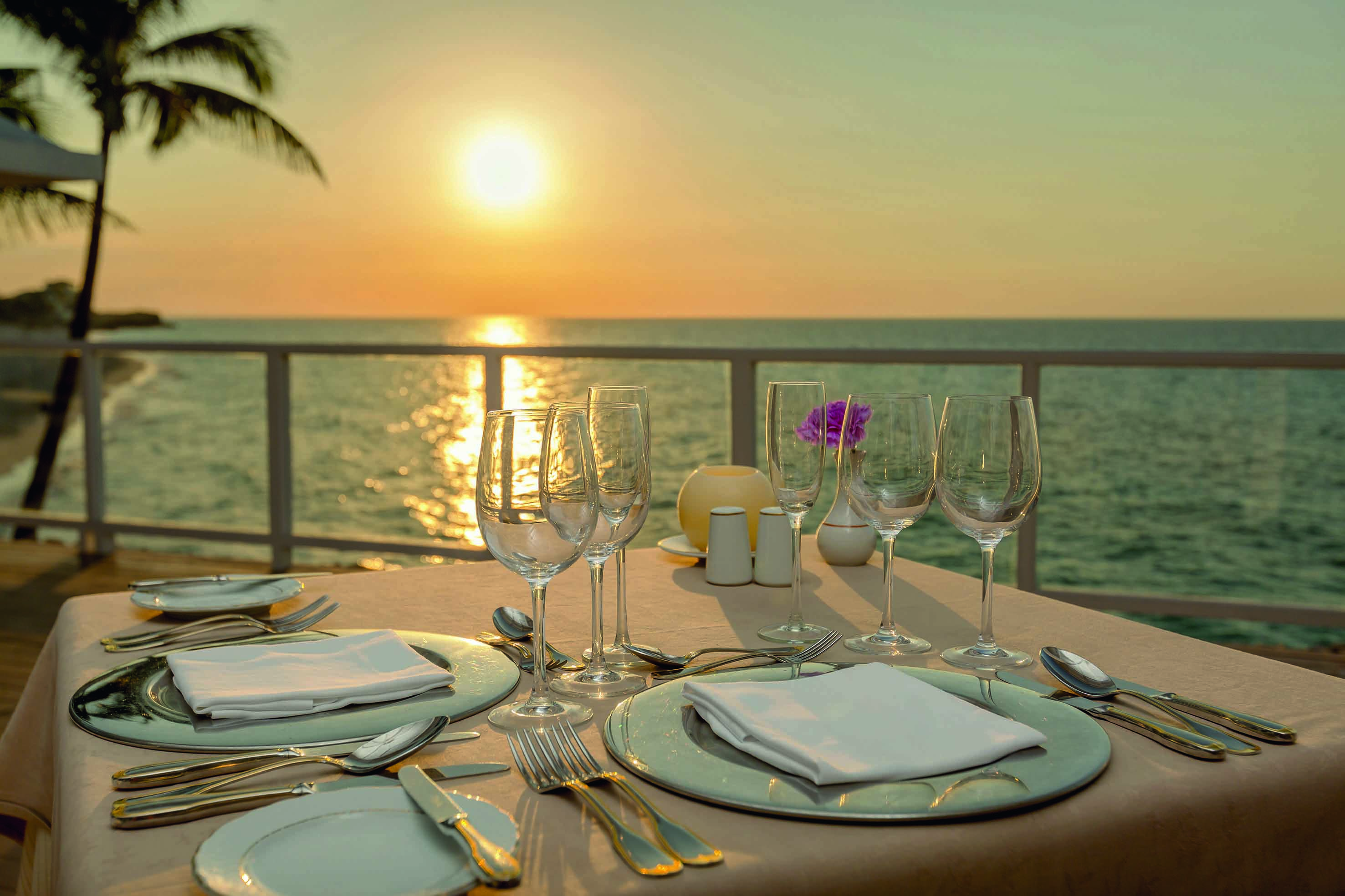 a table set for a dinner with a view of the ocean