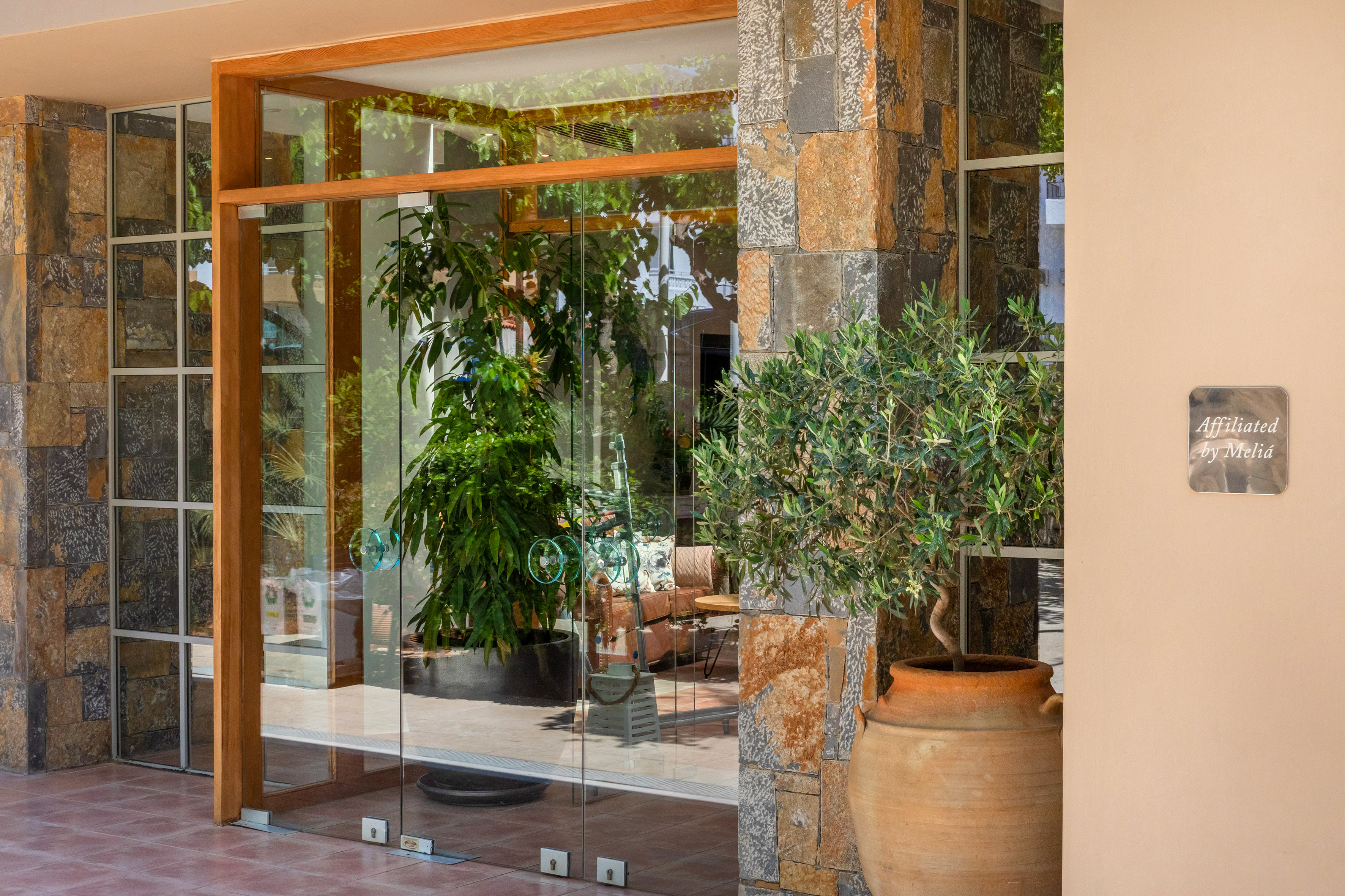 a glass door with a potted plant in front of it