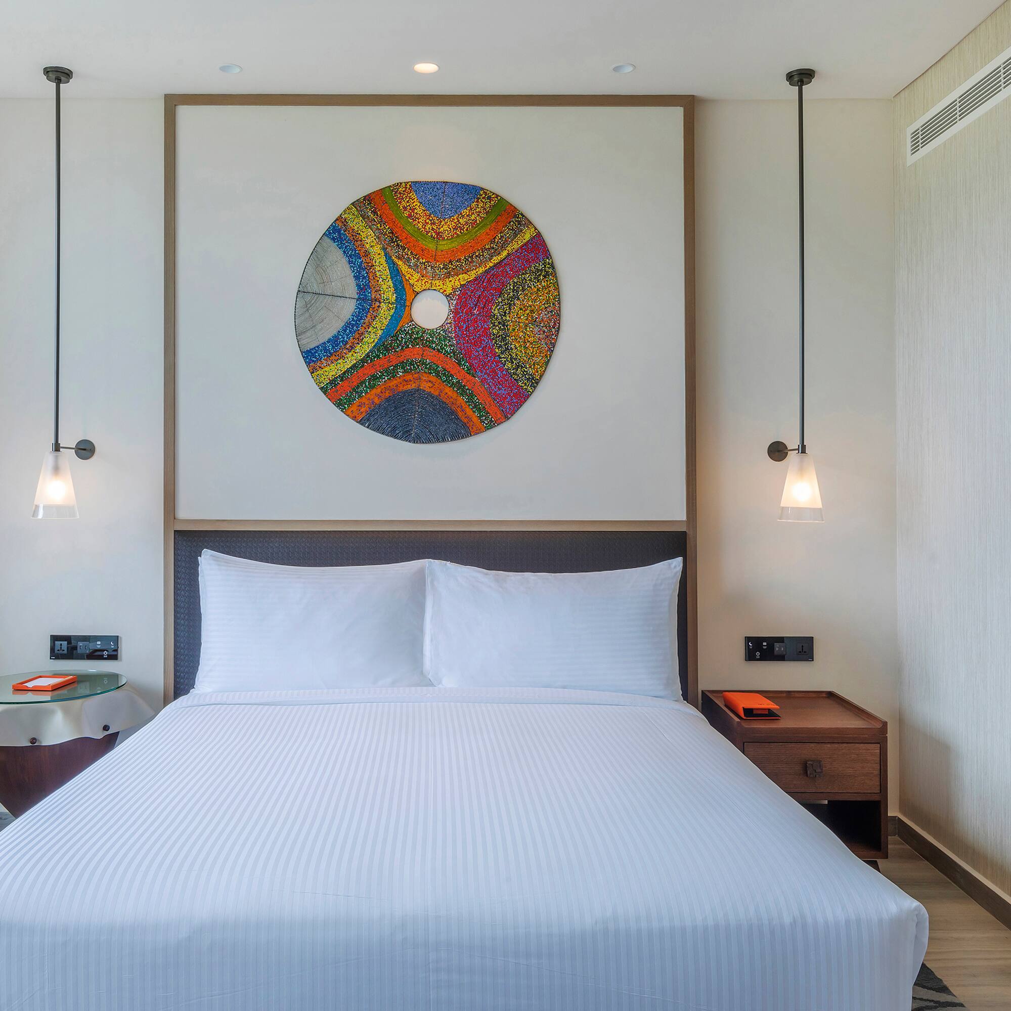 a bed with a colorful circle on the wall