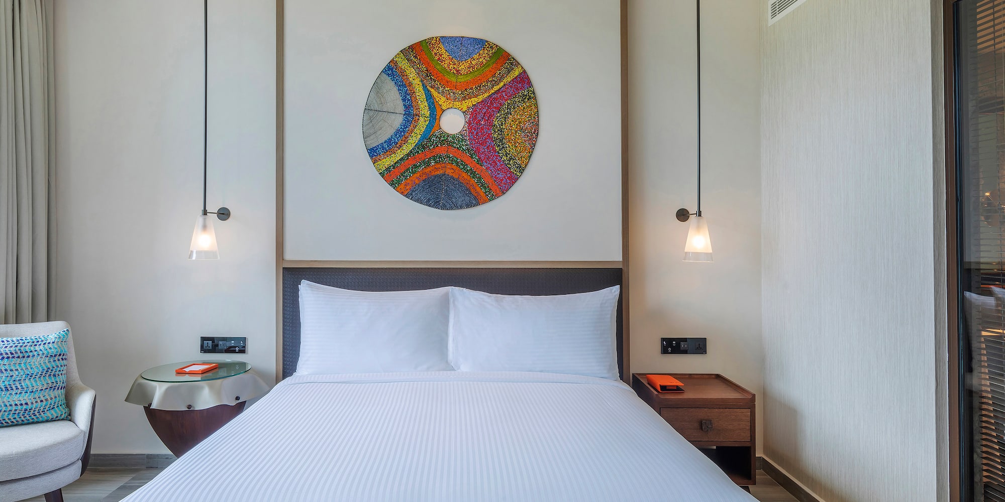 a bed with a colorful circle on the wall