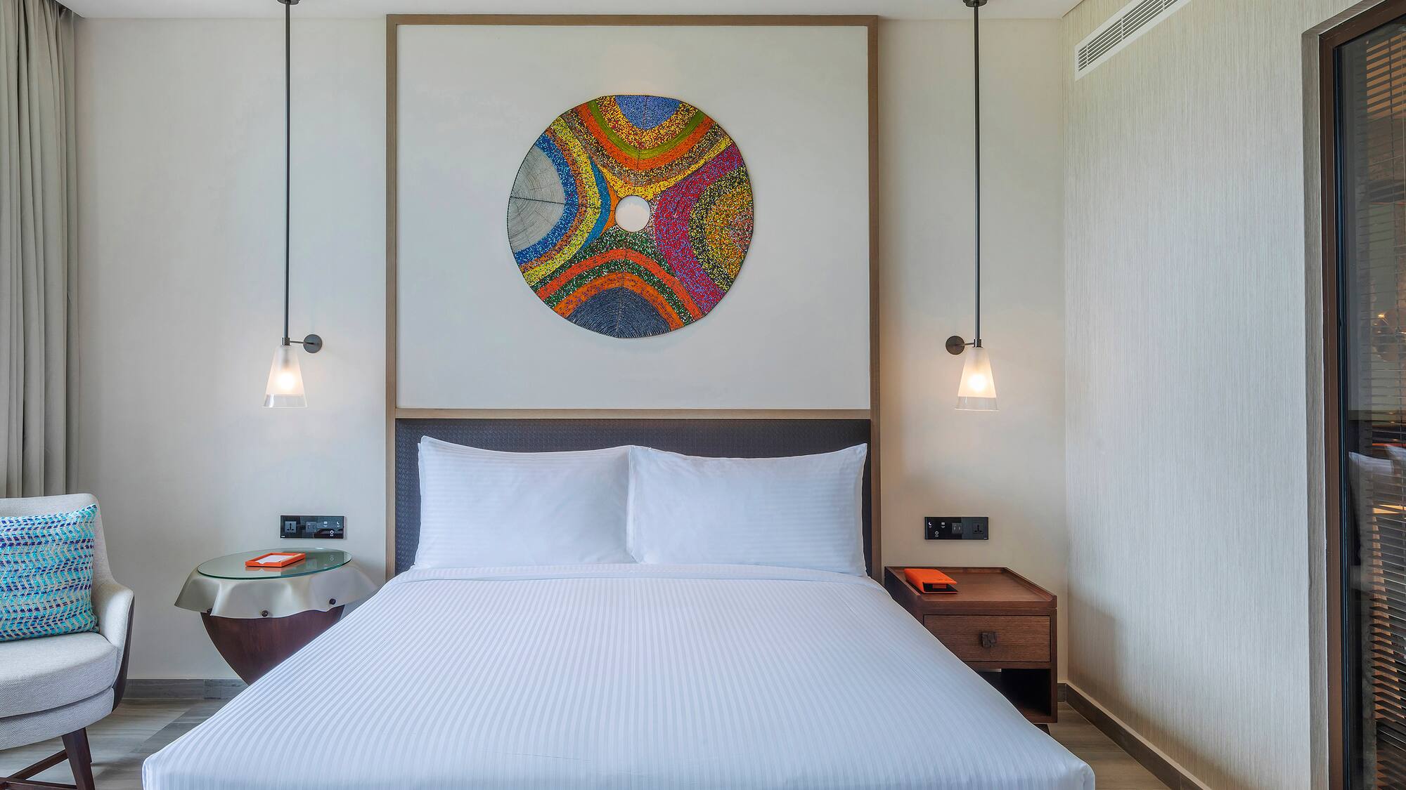 a bed with a colorful circle on the wall