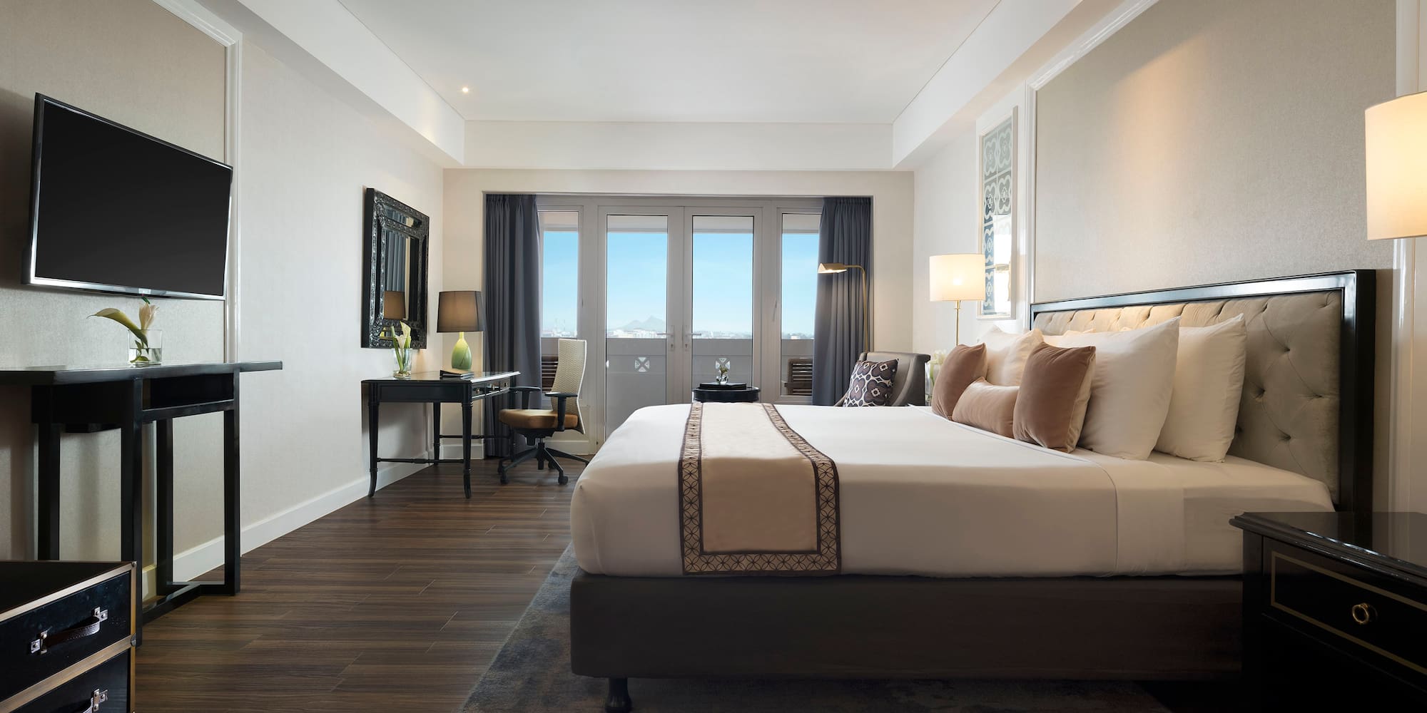 a room with a bed and a desk and a television