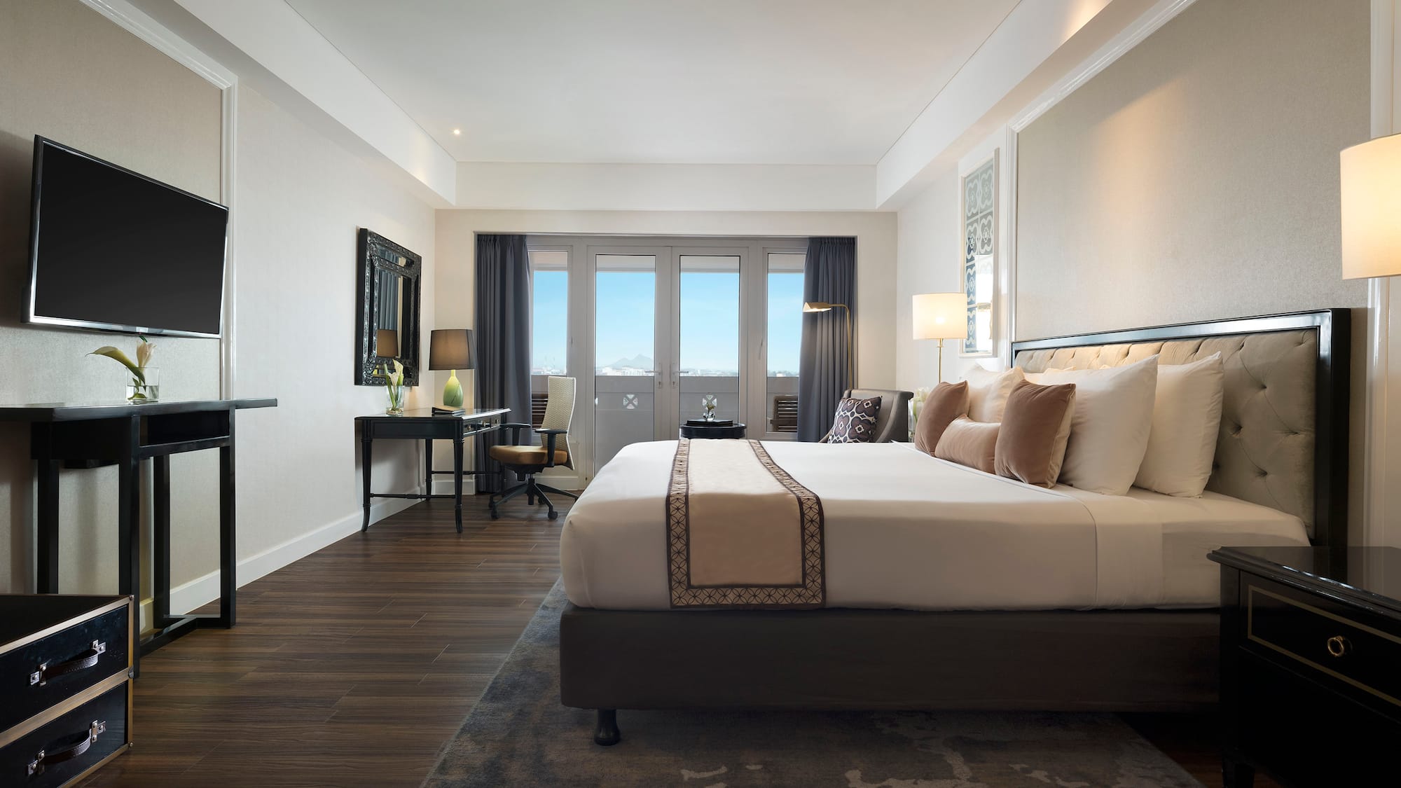 a room with a bed and a desk and a television