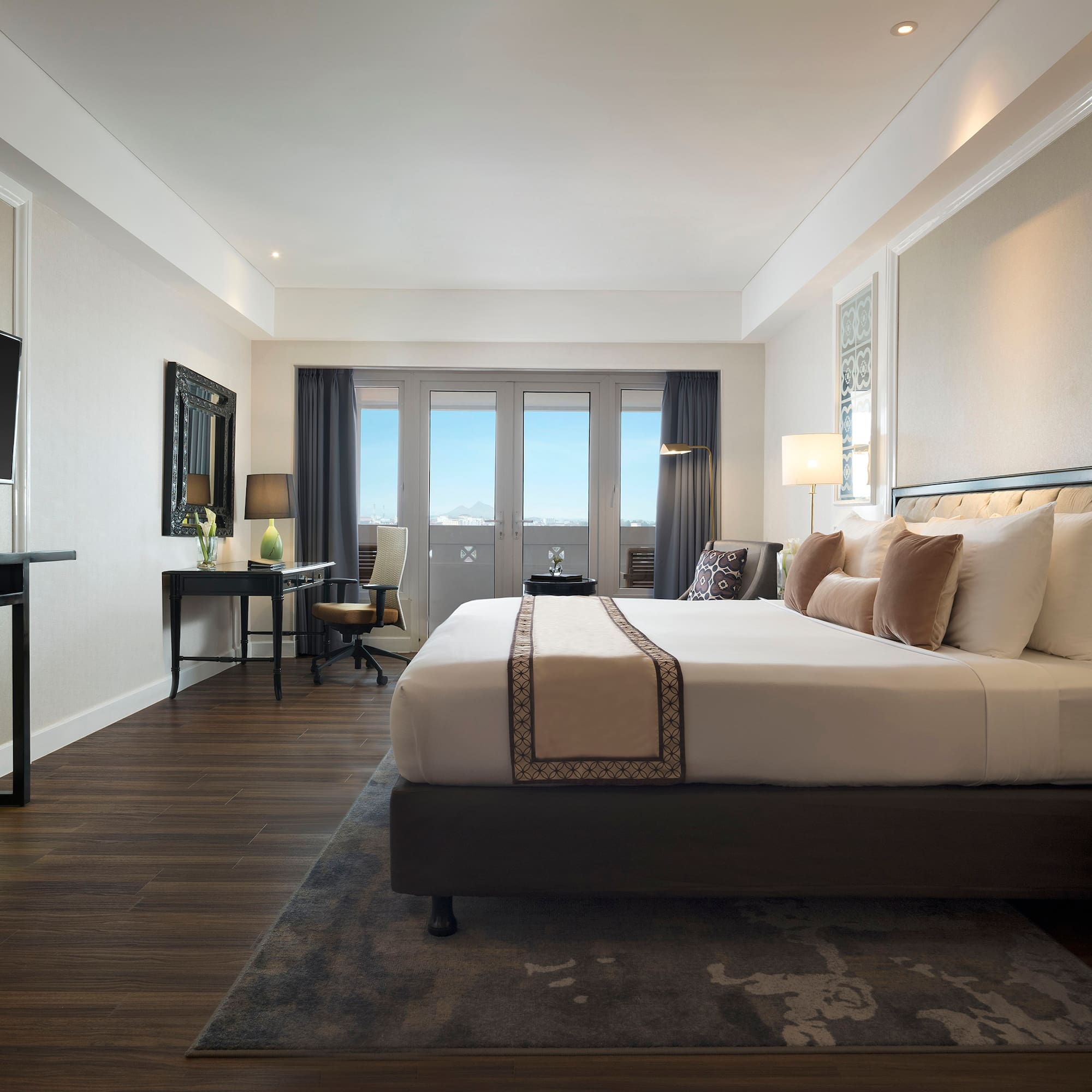 a room with a bed and a desk and a television