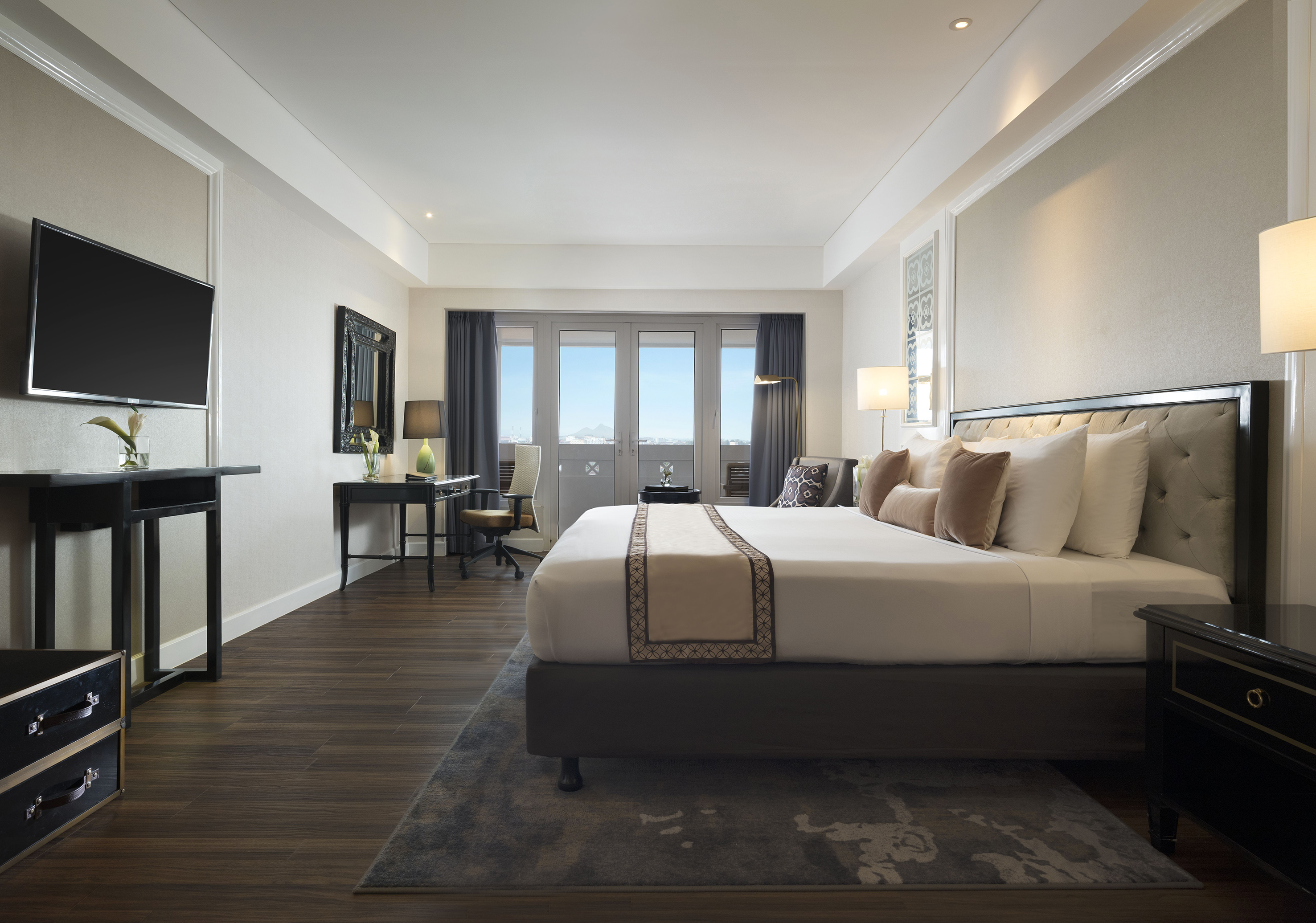 a room with a bed and a desk and a television