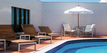 a pool with chairs and umbrella