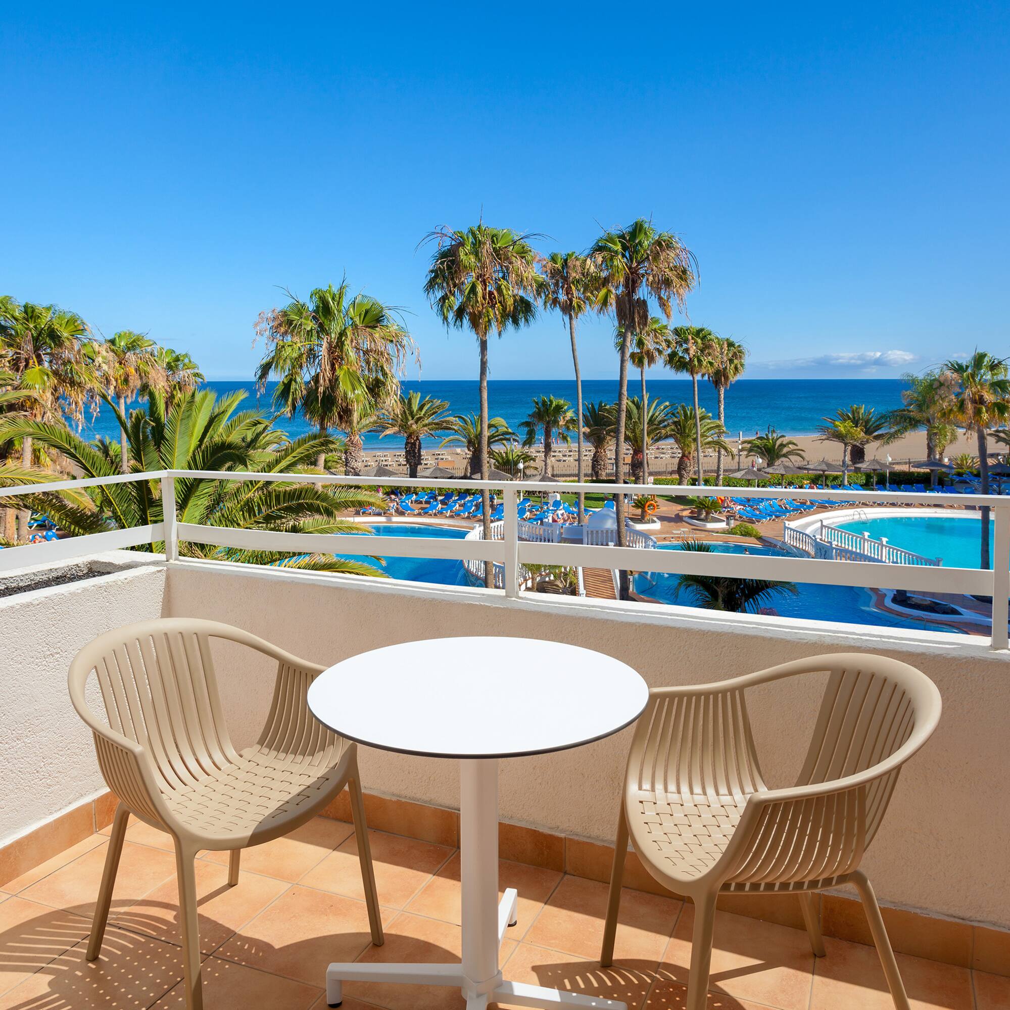 a table and chairs on a balcony overlooking a body of water