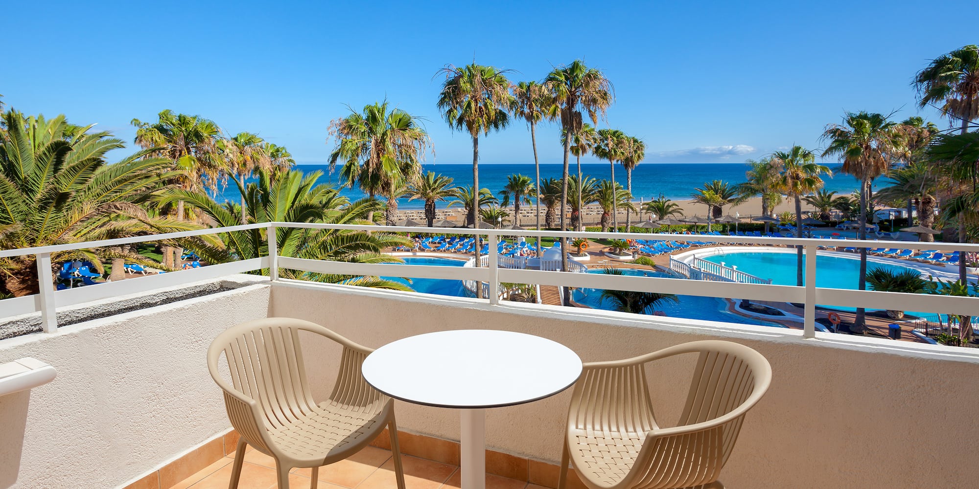 a table and chairs on a balcony overlooking a body of water