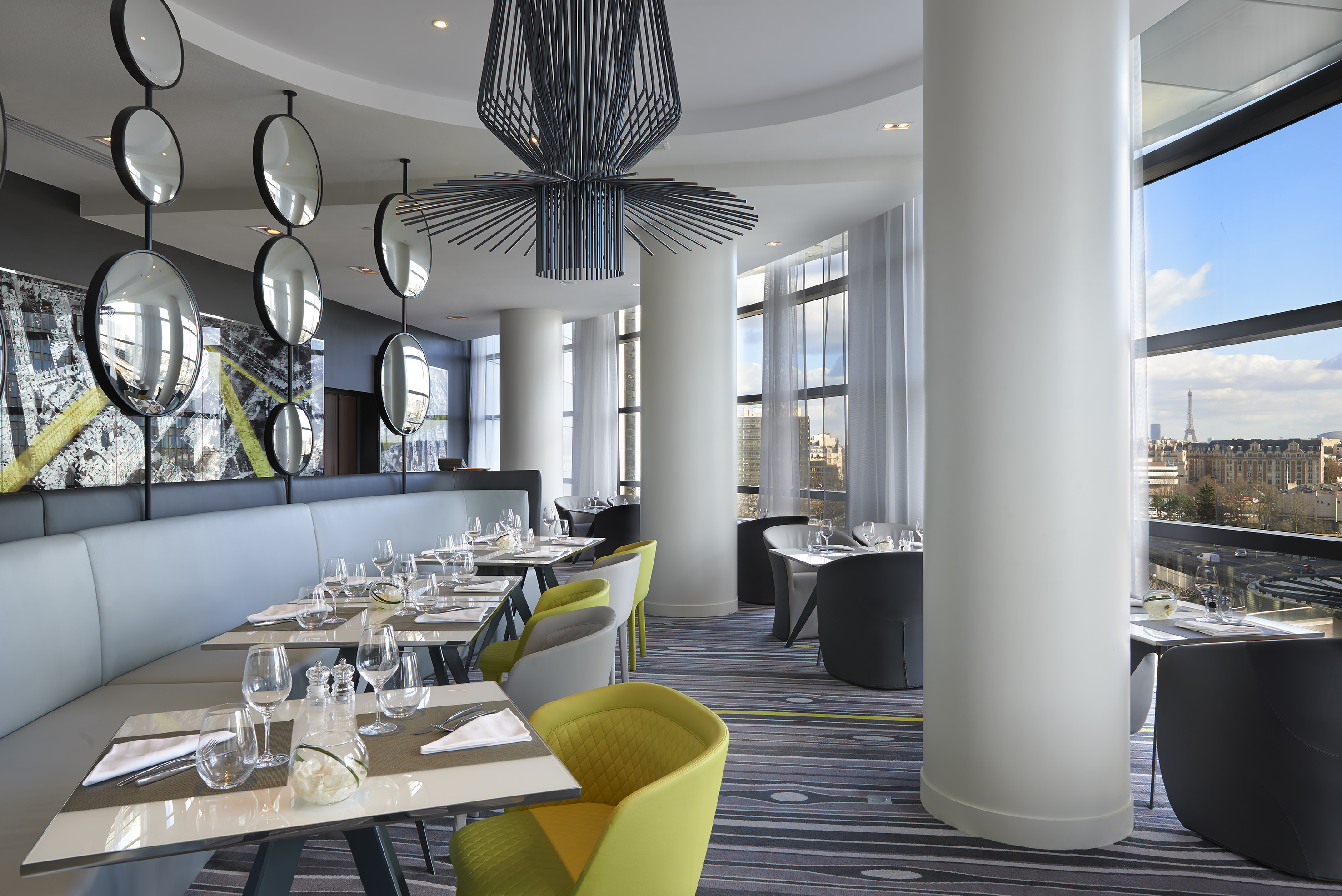 Modern restaurant dining room with Parisian cityscape and Eiffel Tower view.