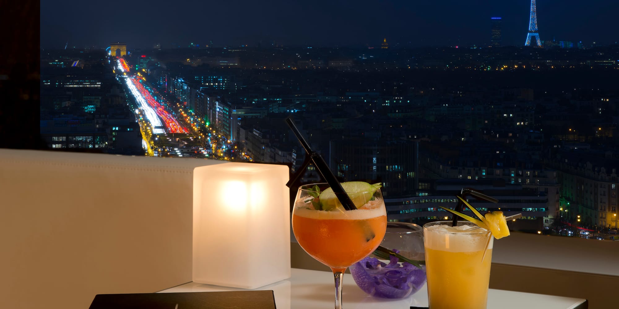 a table with drinks on it and a city view at night