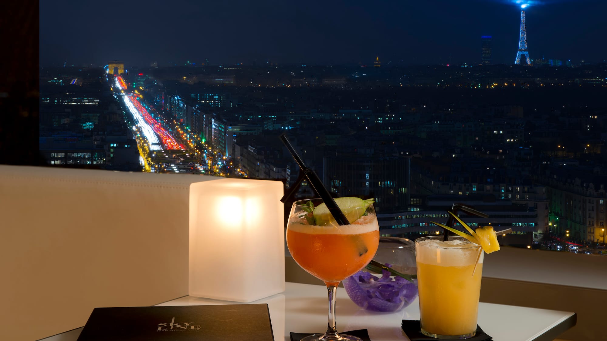 a table with drinks on it and a city view at night