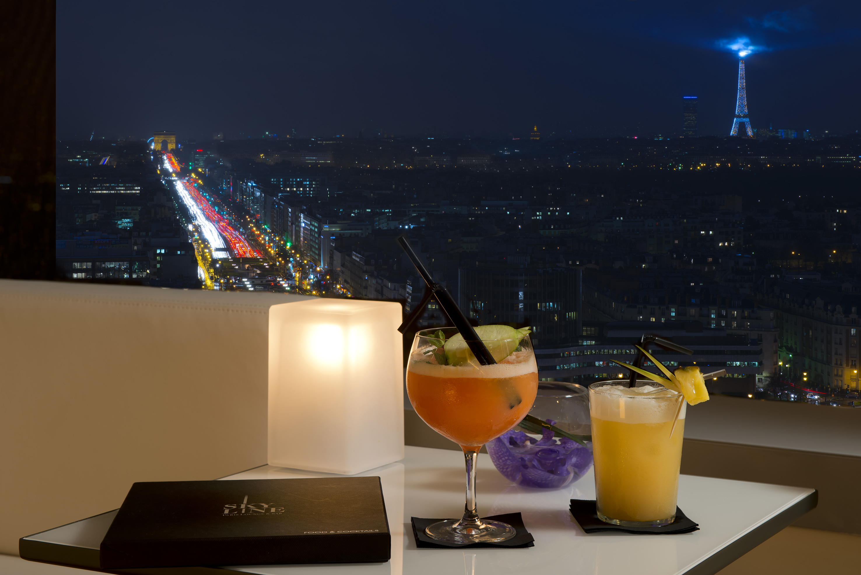 a table with drinks on it and a city view at night