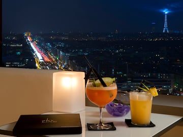 a table with drinks on it and a city view at night