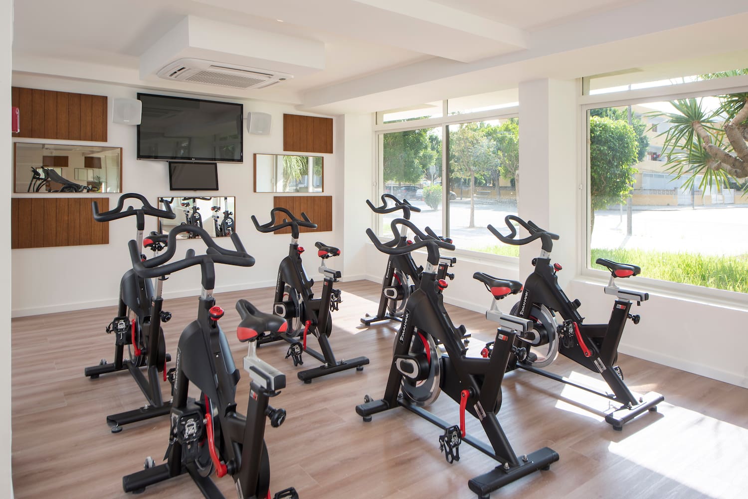 a room with exercise bikes and a tv