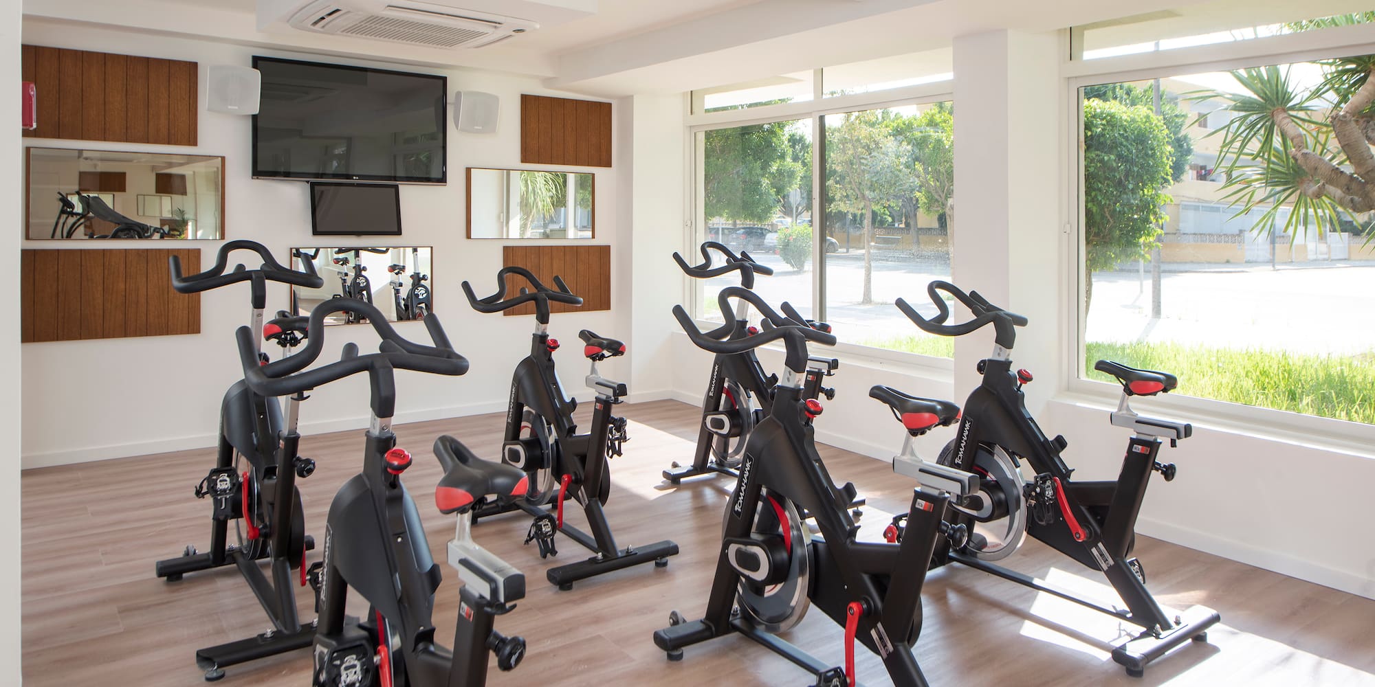 a room with exercise bikes and a tv
