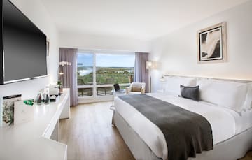 a bedroom with a large window and a large bed