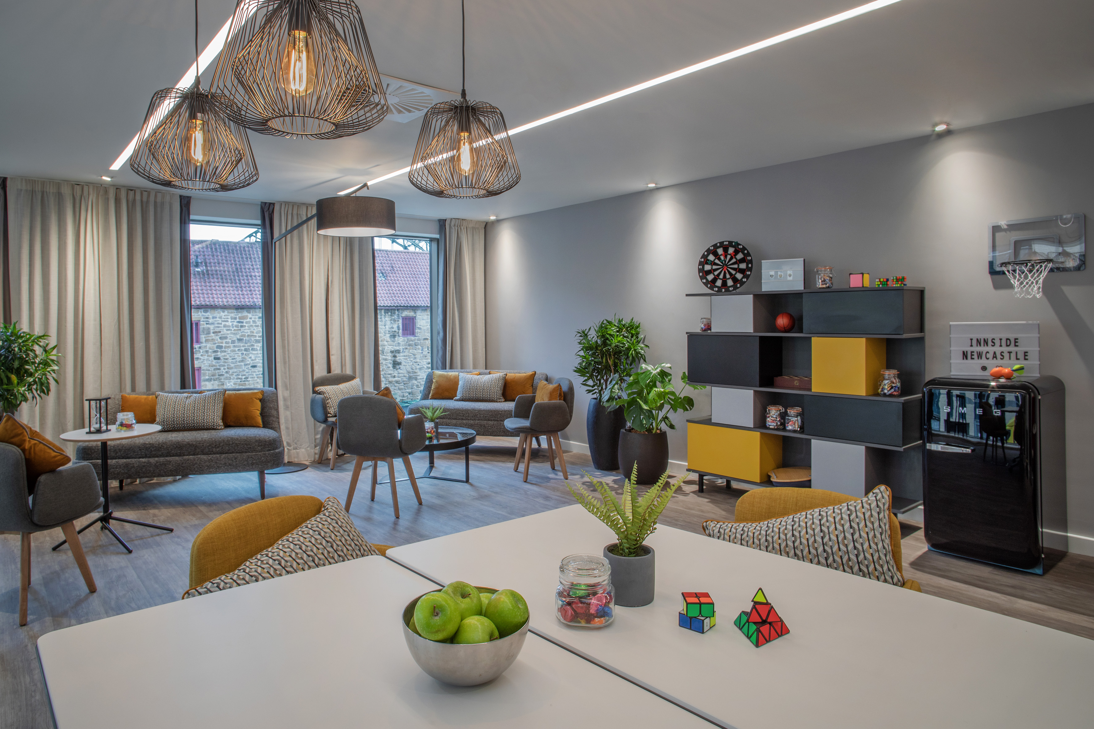Innside Newcastle hotel lounge: stylish seating, modern decor, plants, games area.