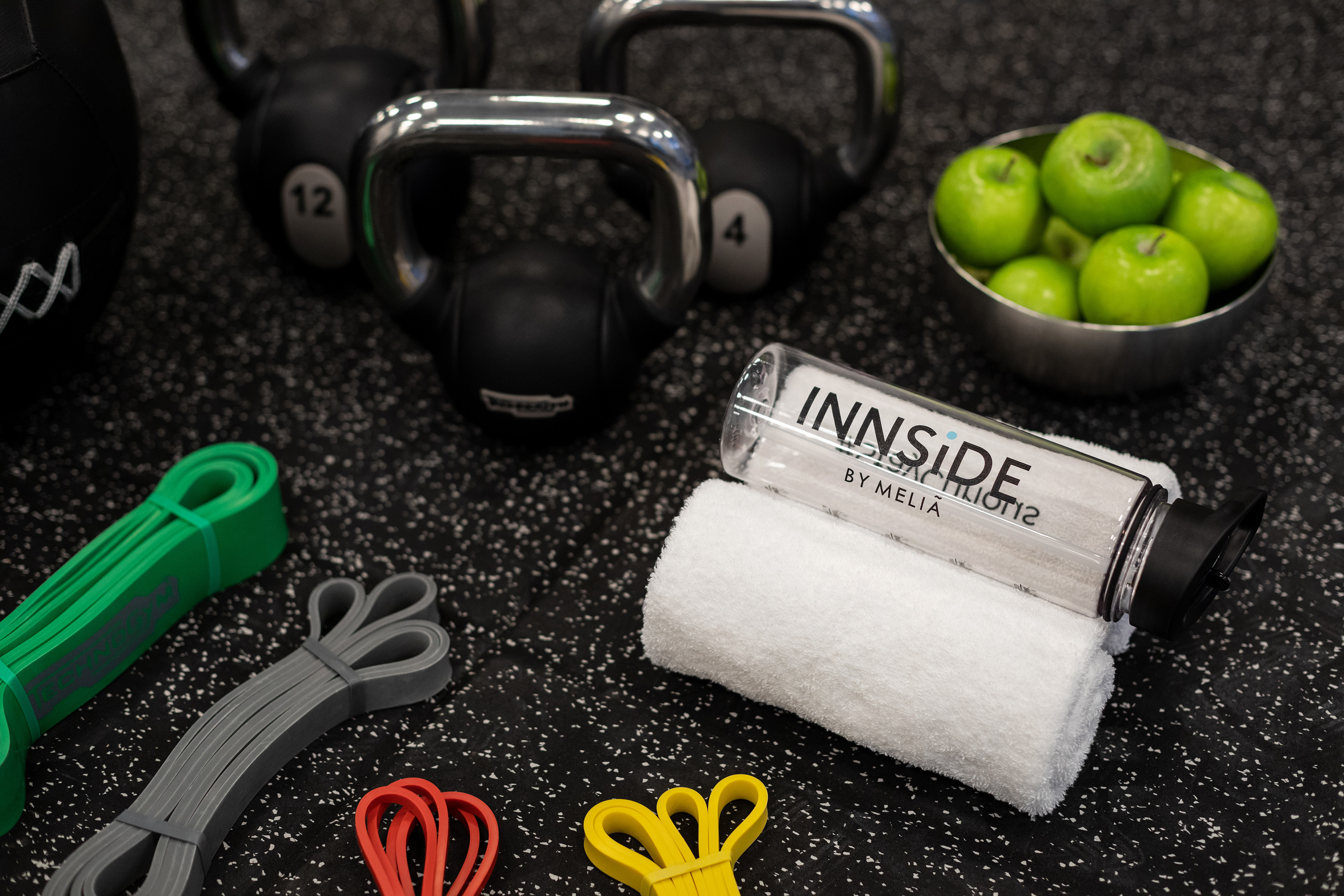INNSIDE water bottle, kettlebells, resistance bands, and green apples.