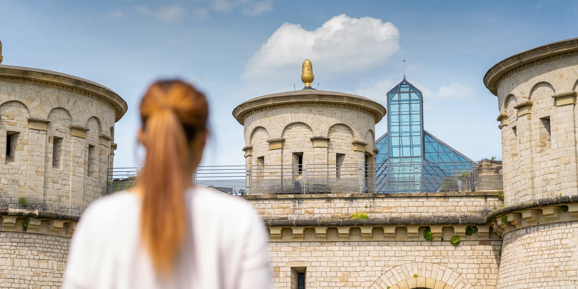a woman standing in front of a stone building