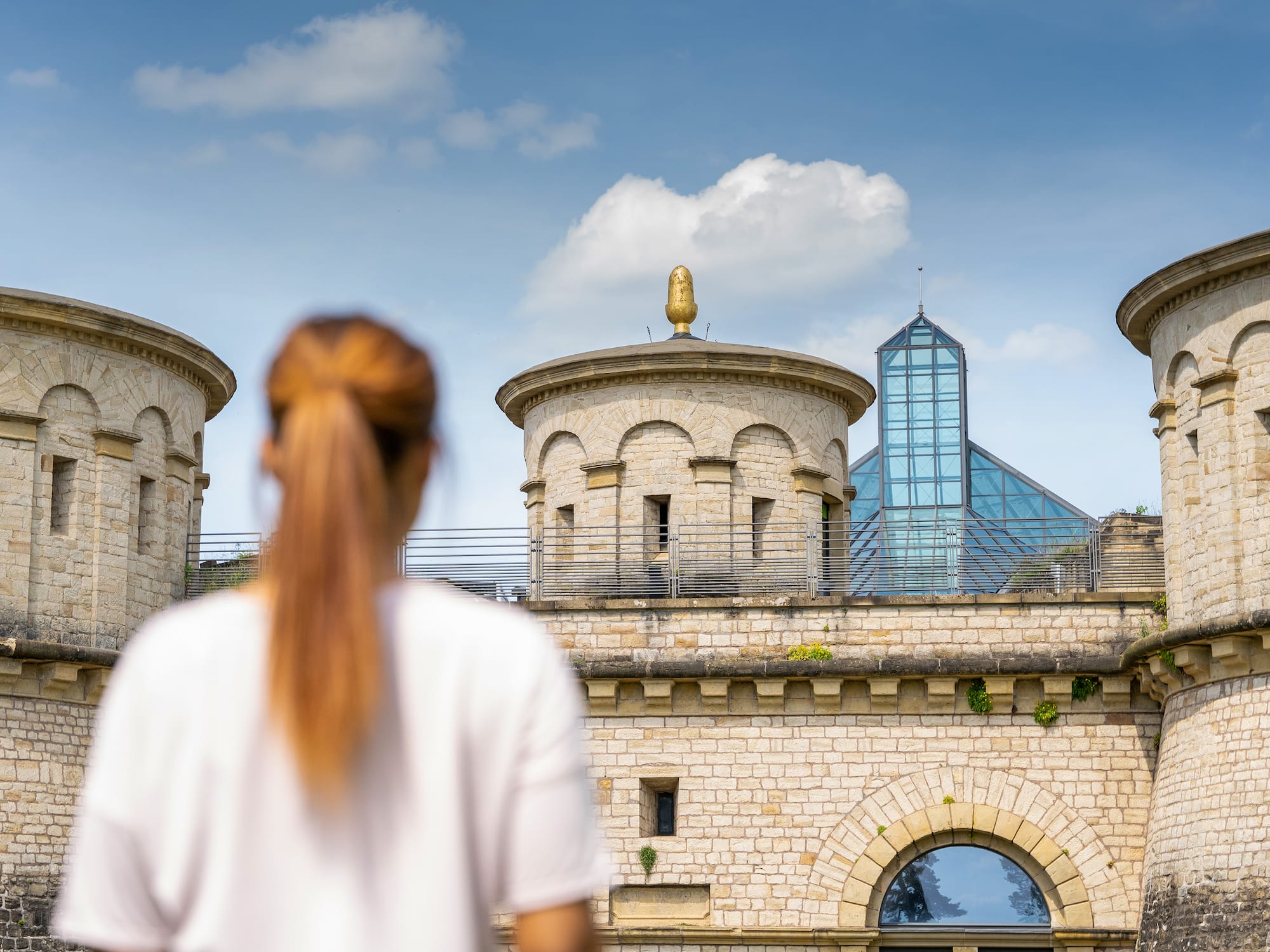 a woman standing in front of a stone building