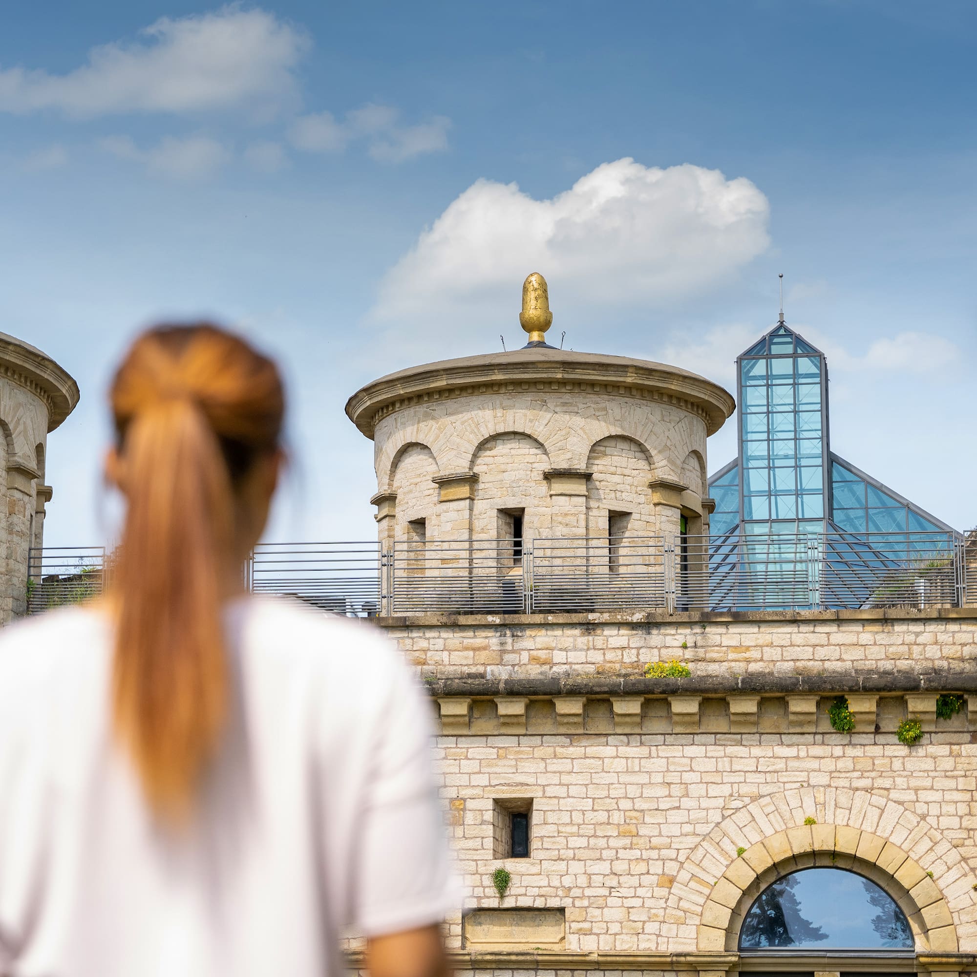 a woman standing in front of a stone building