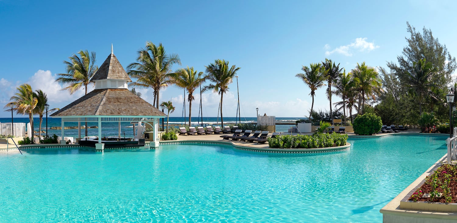 a pool with lounge chairs and a gazebo