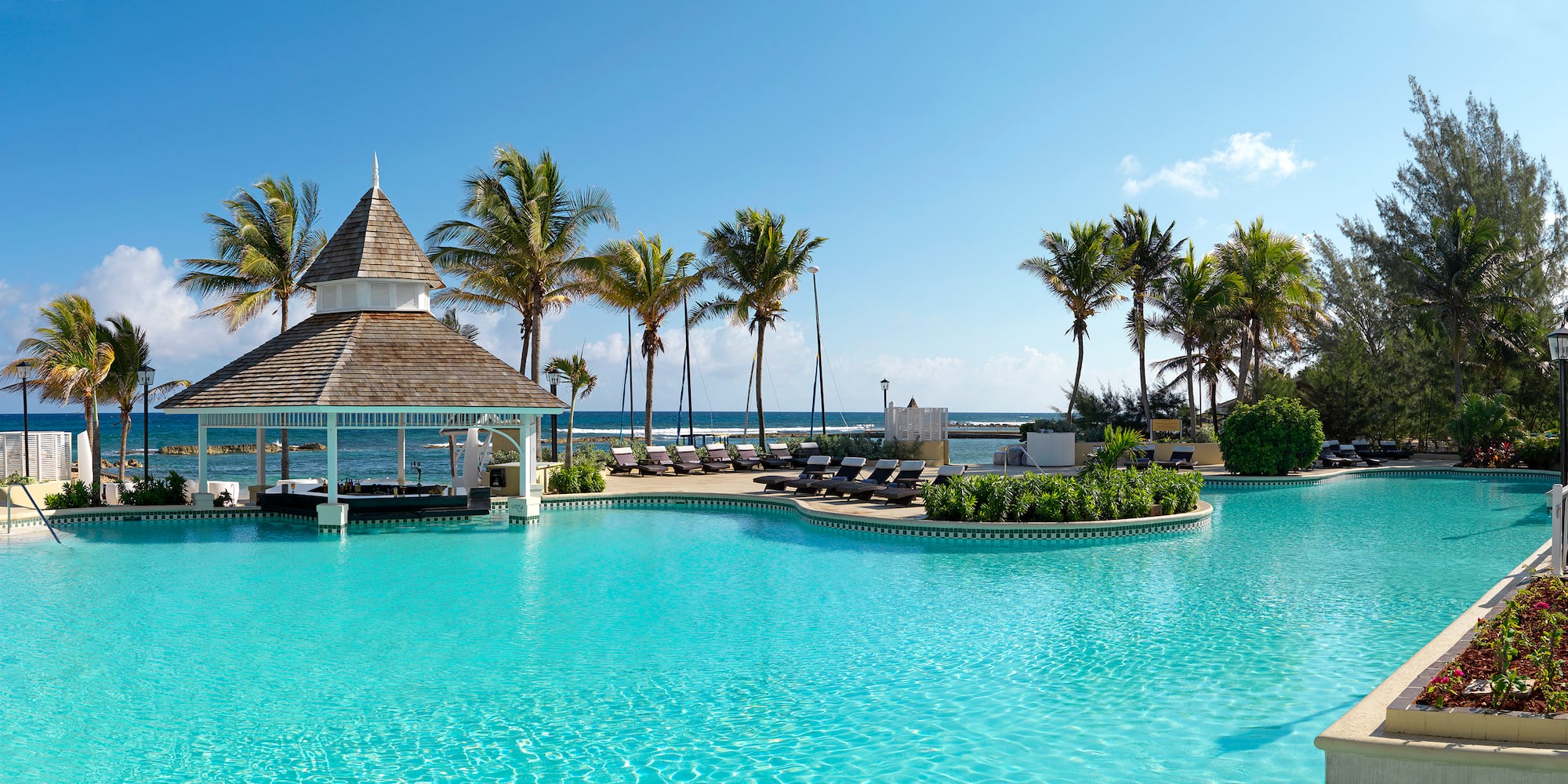 a pool with lounge chairs and a gazebo