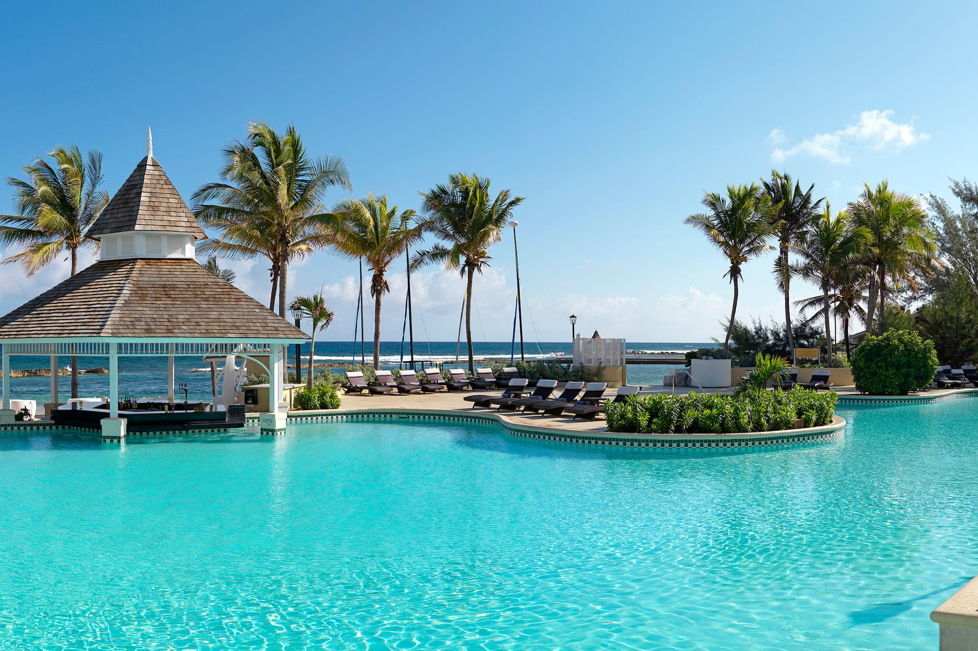 a pool with lounge chairs and a gazebo