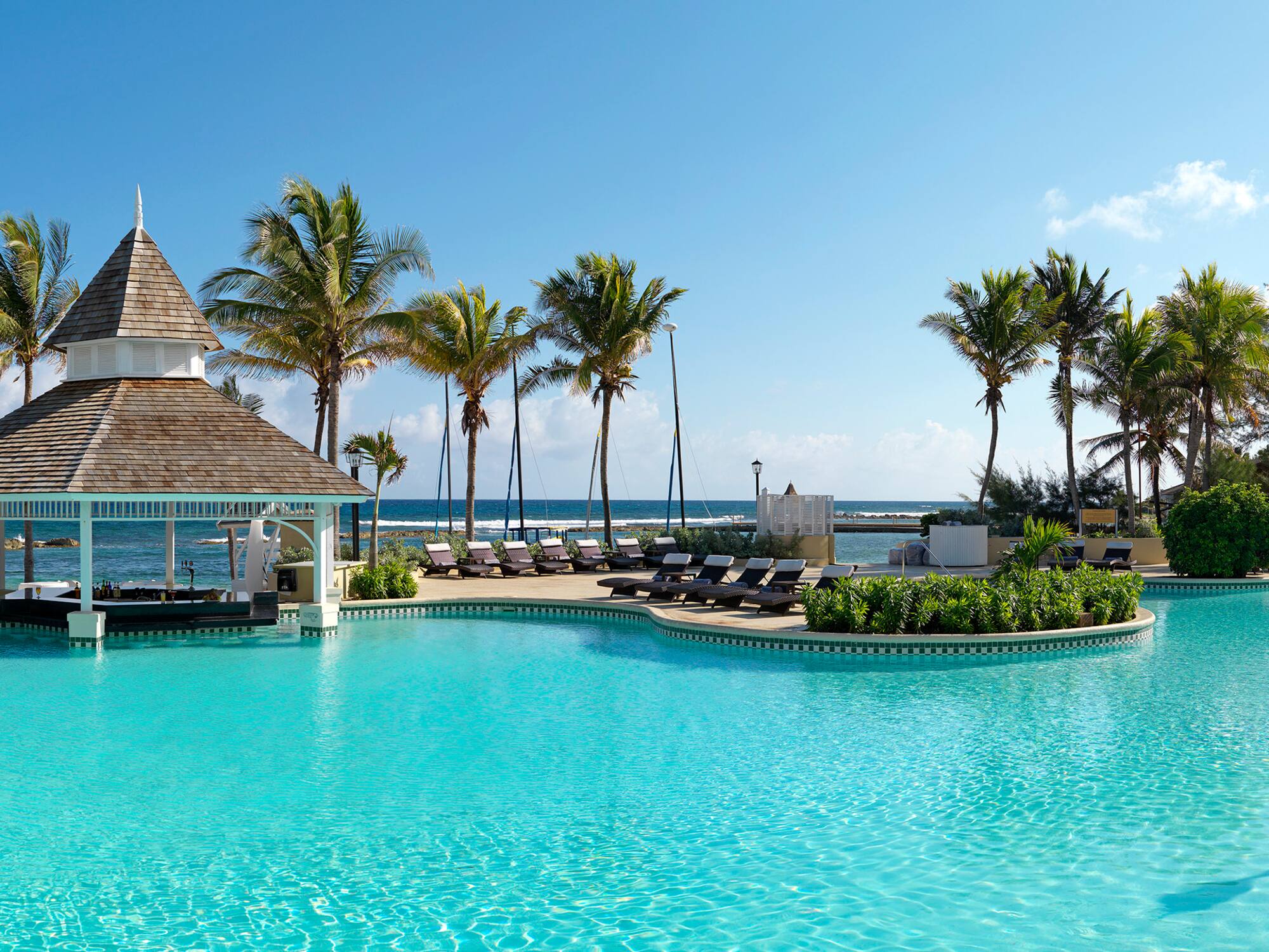 a pool with lounge chairs and a gazebo