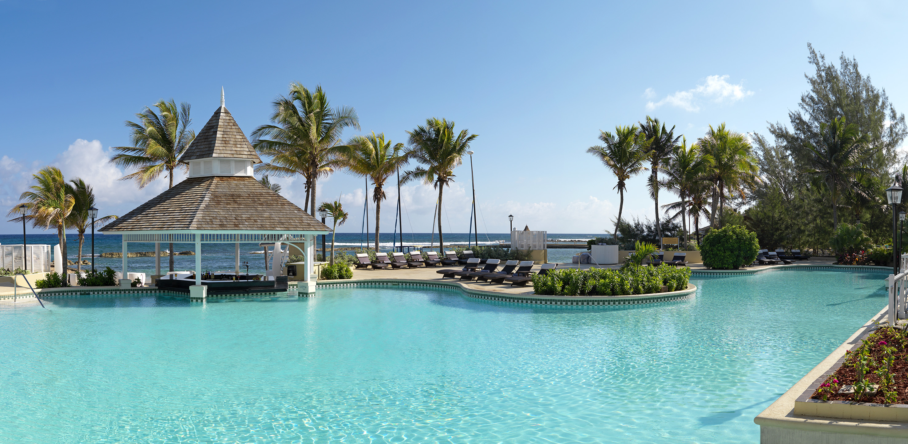 a pool with lounge chairs and a gazebo