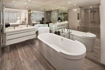 a bathroom with a large tub and a large mirror
