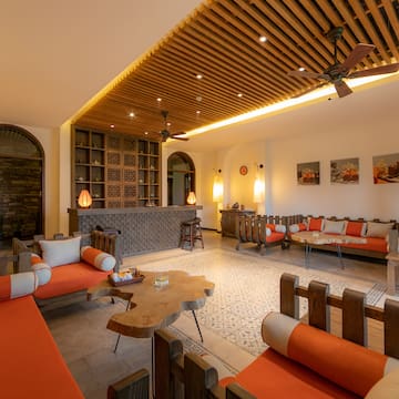 a room with orange couches and a table