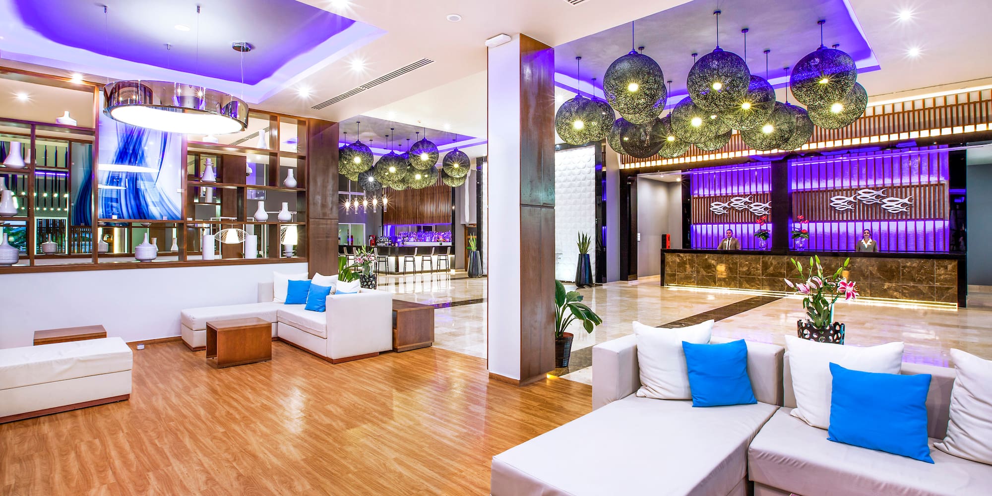 a lobby with white couches and blue and purple lights